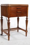 A 1930's mahogany sewing table having inset White Rotary sewing machine on flip over action