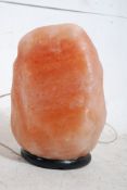 A retro 1970's large Himalayan rock salt crystal table lamp of natural form having a distinct orange