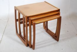 A 1970's retro G-Plan style teak wood nest of graduating tables. Shaped supports with stretchers