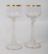 A pair of Victorian cut glass fluted wine goblets with gilt decoration having hollow stems. 19cm