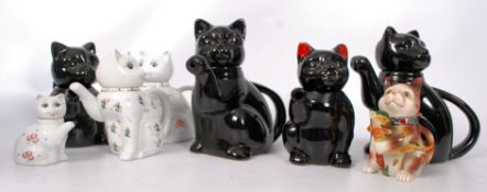 Collection of china teapots in the form of cats.
