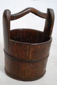 A 19th century Victorian oak bucket having banded metal surround with shaped carry handle. 48cms