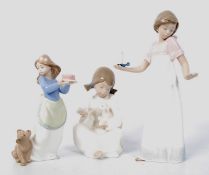 3 Nao / Lladro figurines of a girl with candle (27cm tall), girl with lamb, and girl with dog.