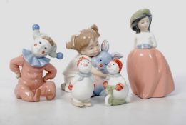 A collection of Nao Lladro figurines include a clown child, small winter snowmen, child & rabbit,