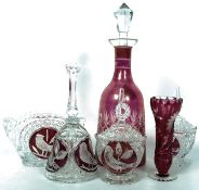 A collection of cranberry style cut glass to include decanter, bell and other items. Tallest 32cm