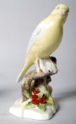 A Royal Doulton model of a yellow canary on a tree stump, with flowers.