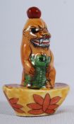 A Chinese porcelain snuff bottle in the form of an angry temple dog with climbing lizard. 7cm tall.