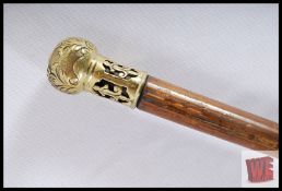 A gents Malacca walking cane with heavy crafted brass knop with Fleur De Lys decoration