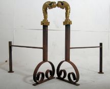 A set of cast iron and brass fire dogs / andirons. The cast iron bases with scolled supports