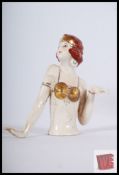 An Art Deco style Bisqueware figurine of a 1920's lady with gold top and red hair. 10cm tall.