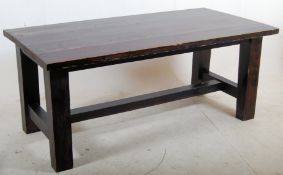 A very large solid stained dark pine heavy refectory dining table stood on squared legs supporting