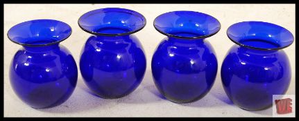 Four Bristol Blue Glass small baluster vases with waisted necks and flared lips. 12cm tall.