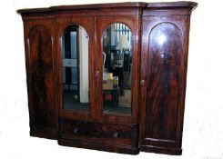 A large Victorian flame mahogany triple breakfront wardrobe linen press. The central twin mirror