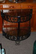 A retro wrought iron two tier occasional table with amber / smoked Flemish patterned glass. H65cm