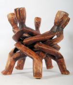 A carved hardwood African tribal art stand / planter, depicting intertwined legs and five tribal