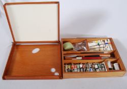 A wooden artists easel box with sliding easle, complete with oils, water colour paints, brushes etc