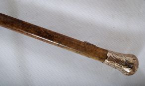 A walking cane with Malacca shaft and silver metal knop with embossed decoration