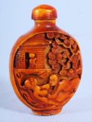 A 1960's Chinese Cinnabar orange composition snuff bottle with erotic risque decoration. 6cm tall.