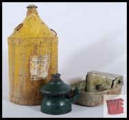 A 20th century vintage oil can together with an early 20th century military jack and a stone
