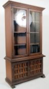 A large oak continental style library bookcase. The cupboard base having decorative panelled doors