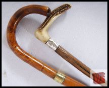 Two walking sticks; one with a rustic shaft, silver band and horn handle, the other with a fine