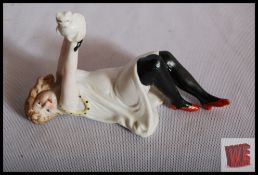 An Art Deco style Bisqueware figure of a girl with black stockings and red shoes holding a cat.