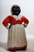 A vintage 'Jolly Negro' Negress cast iron money box in the form of a maid. 20cm tall.