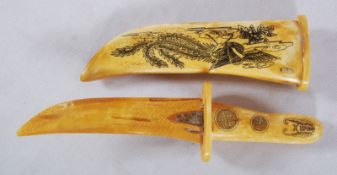 A 1960's Chinese scrimshaw bone scratch carved dagger and sheaf. The handle and sheaf decorated with