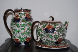 A Royal Doulton Imari tea pot (AF) along with a teapot stand and hot water pot. (18cm)
