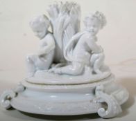 A creamware / parian ware 19th century cherub adorned figurine having a George Jones initialled