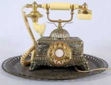A vintage reproduction telephone together with a similar metal decorative salver