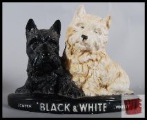 A Black & White Whiskey plaster advertising figure depicting a black terrier seated next to a