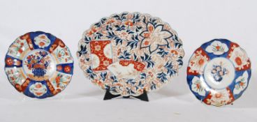 An unusual Chinese Imari oval wall charger with scolloped edge and stalk scene decoration together