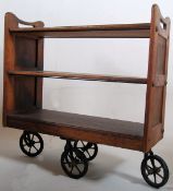 A Victorian solid oak Arts & Crafts 3 tier book trolley. Standing on large cast iron wheels having 3