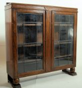1930's Art Deco solid oak bookcase display cabinet. The shaped feet supporting a twin door cabinet