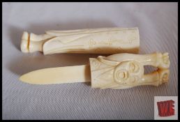 An Ox bone paperknife in the form of an oriental man. 20cm long.