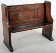 A 19th century pitch pine pew having shaped supports with planked seat and panelled back rest with
