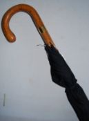 A Swain Adeney Brigg black umbrella with fully marked band to handle