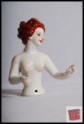An Art Deco style Bisqueware figurine of a half-length nude lady with red hair. 12cm tall.