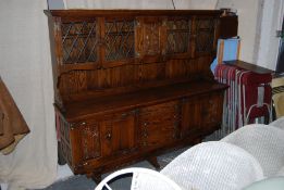 An Old Charm 17th century style sideboard dresser. Lyre supports under a base of drawers and