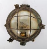 A vintage British world war 2 brass submarine galley lamp with guard (for electricity)