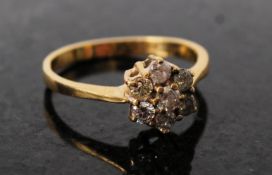 An 18ct gold and diamond cluster ring in daisy form .5 points. The ring set on clasp to bevel with