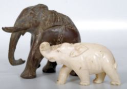 Two carved elephants, one with Indian decoration, the other having rolled trunk.