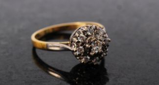 An 18ct gold ladies cluster ring having paved effect with inset diamonds to centre and surround. T