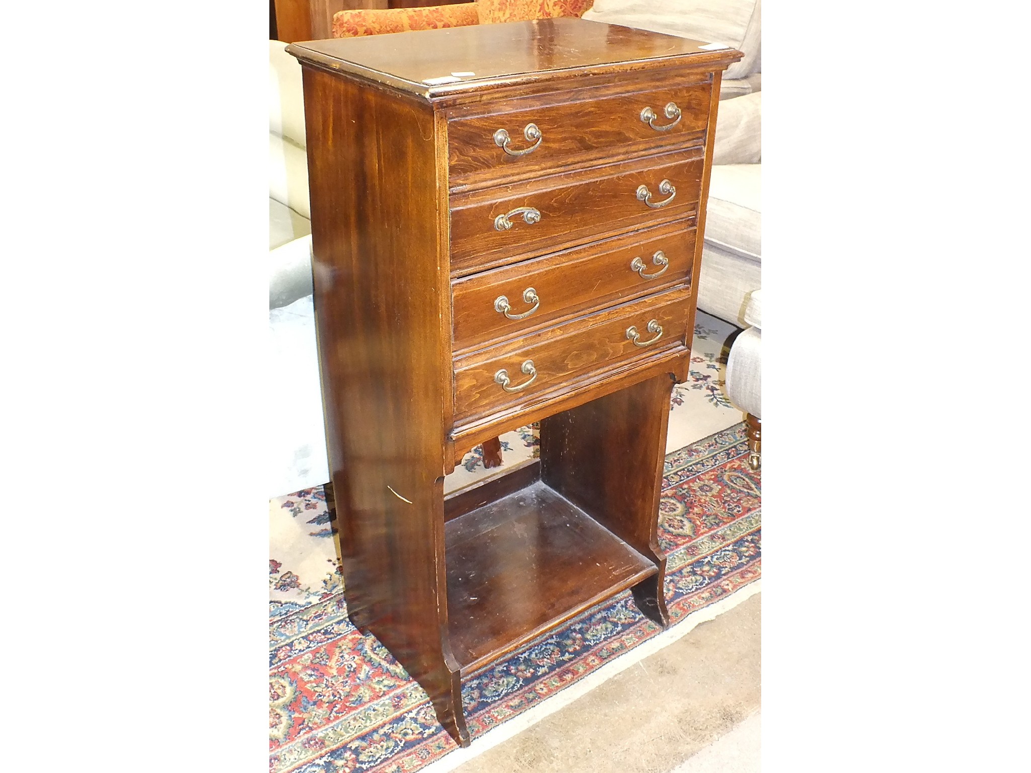An early-20th century stained wood music cabinet, the rectangular top above four drop-down drawers