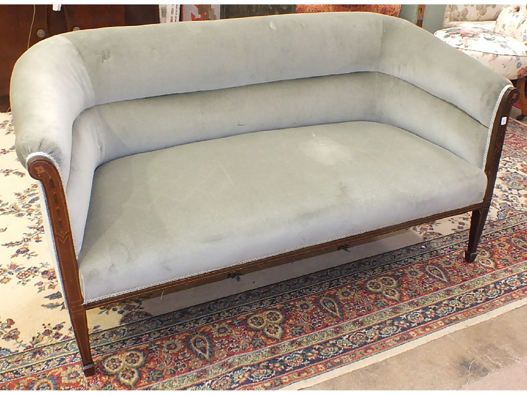 An Edwardian inlaid mahogany upholstered two-seater settee, on square tapered front legs with