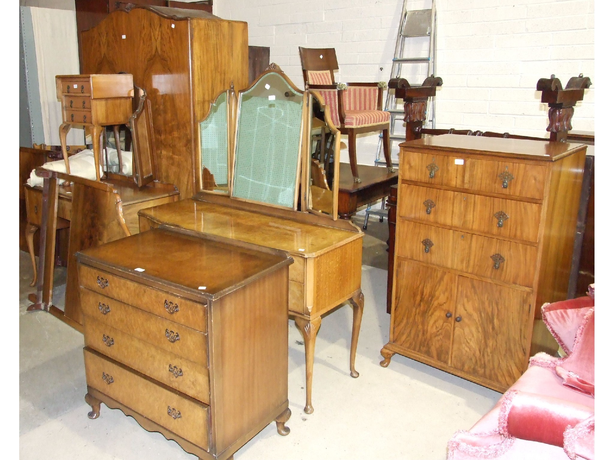 A collection of 1950`s walnut-veneered bedroom furniture, including dressing chests, chest of