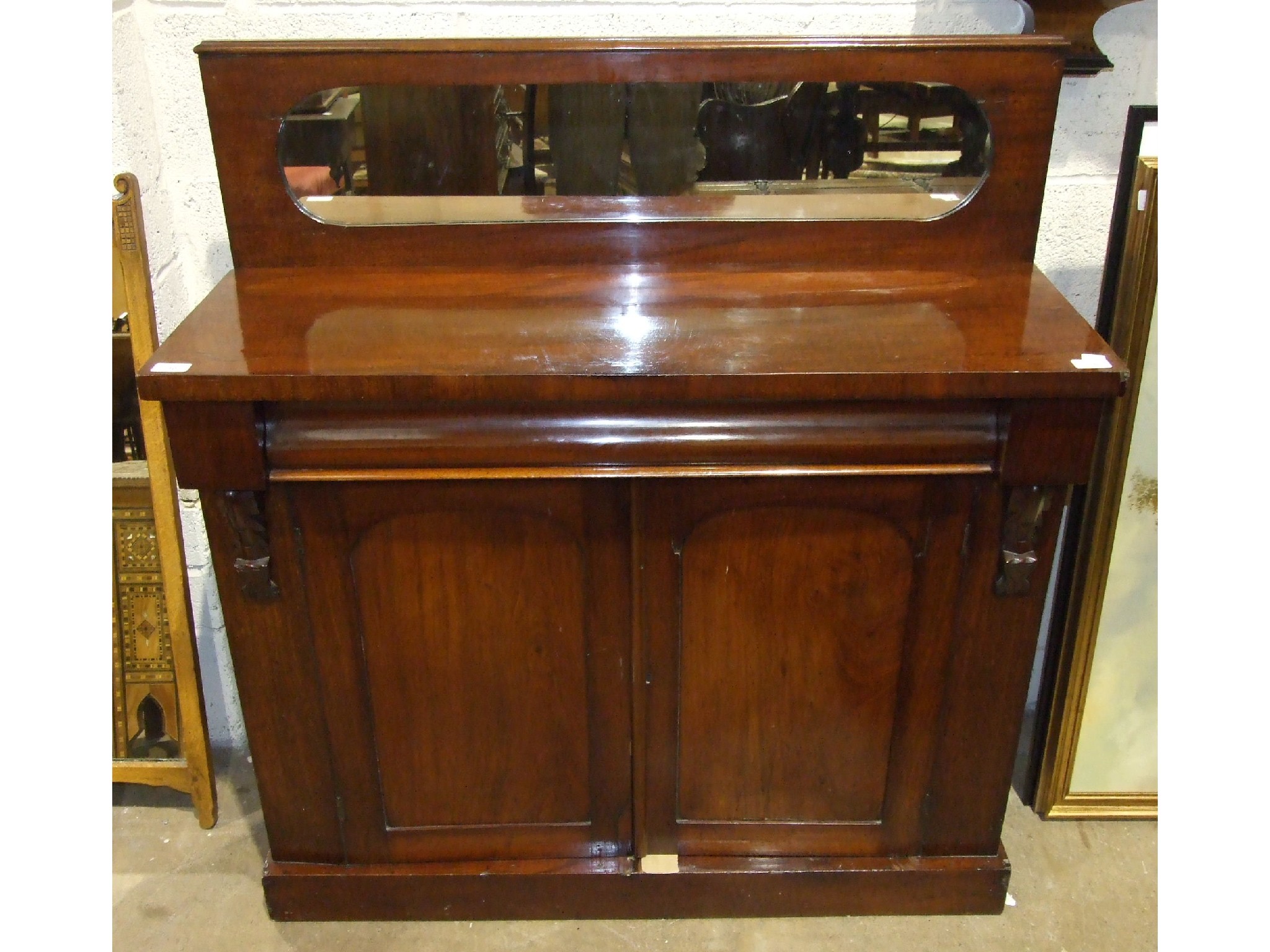 A late 19th century mahogany chiffonier, the rectangular top with low mirrored back above a frieze