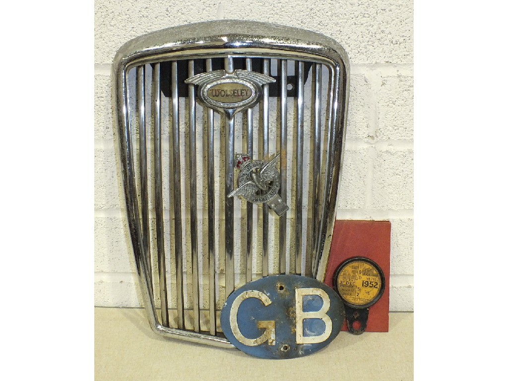 A Wolseley radiator grill with Civil Service Motoring Association car badge, a 1952 tax disc, an