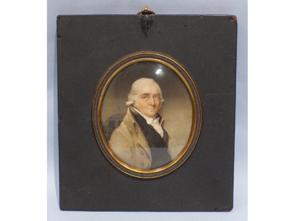 A 19th century oval portrait miniature on ivory of a gentleman with powdered wig, pale brown